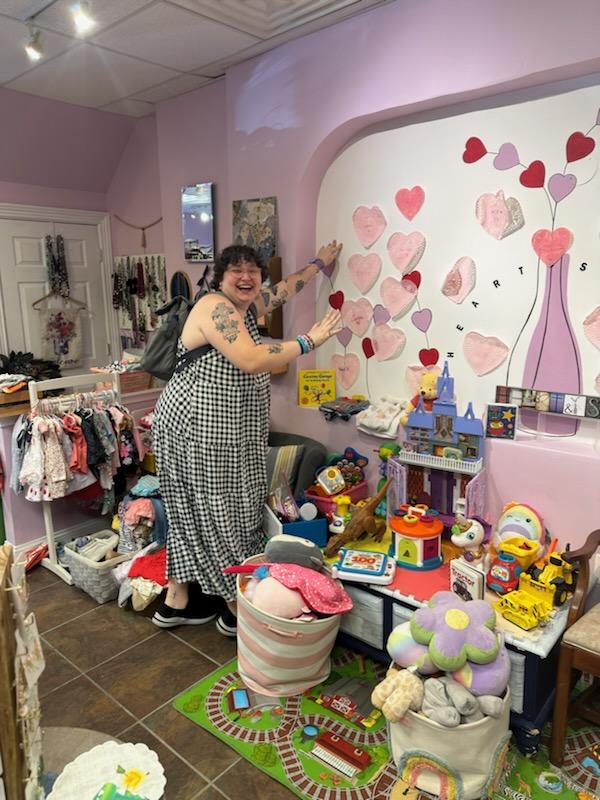 Heart & Soul'd volunteer smiling in the children's section of the store