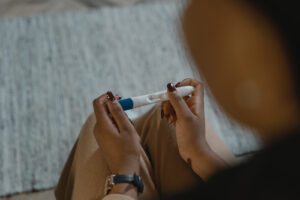 overhead shot of a women holding a positive pregnancy test.